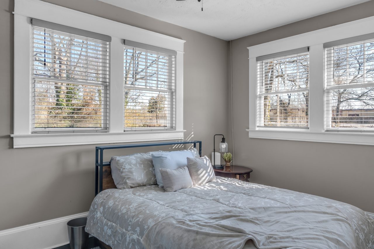 Bedroom with a grey bed and natural light