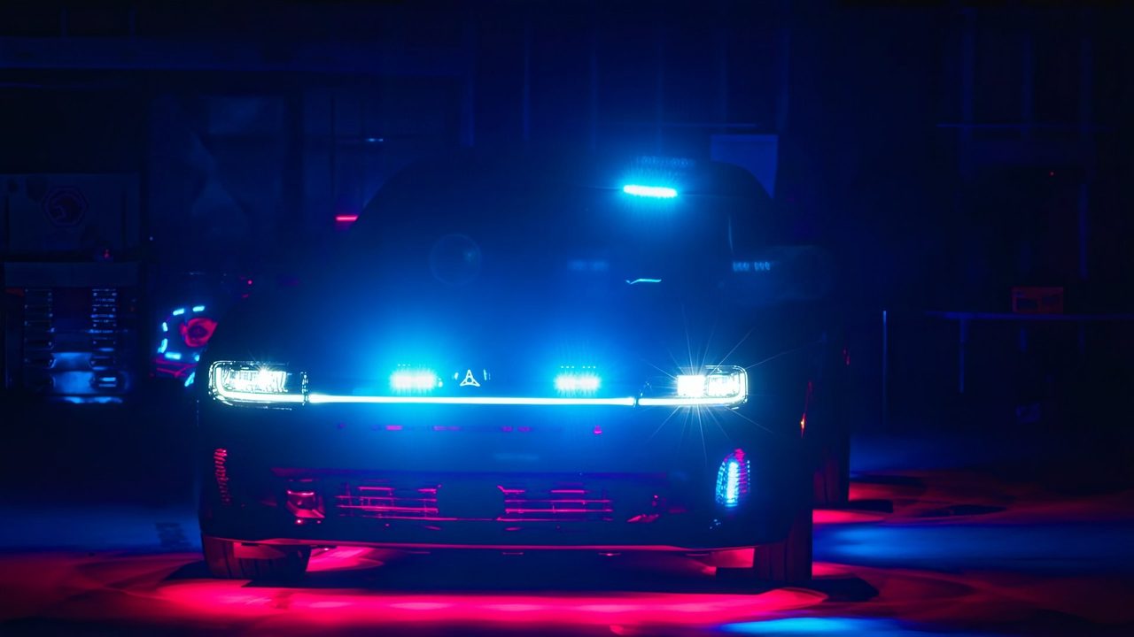 Emergency vehicle lights glowing blue in a dark garage
