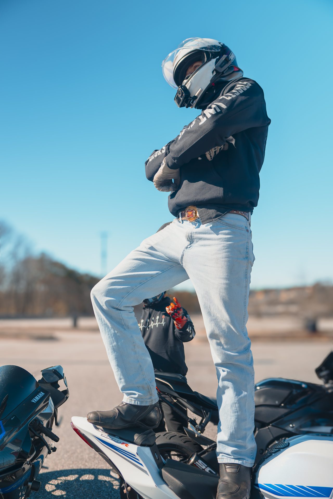 Rider in riding gear standing on a sport bike