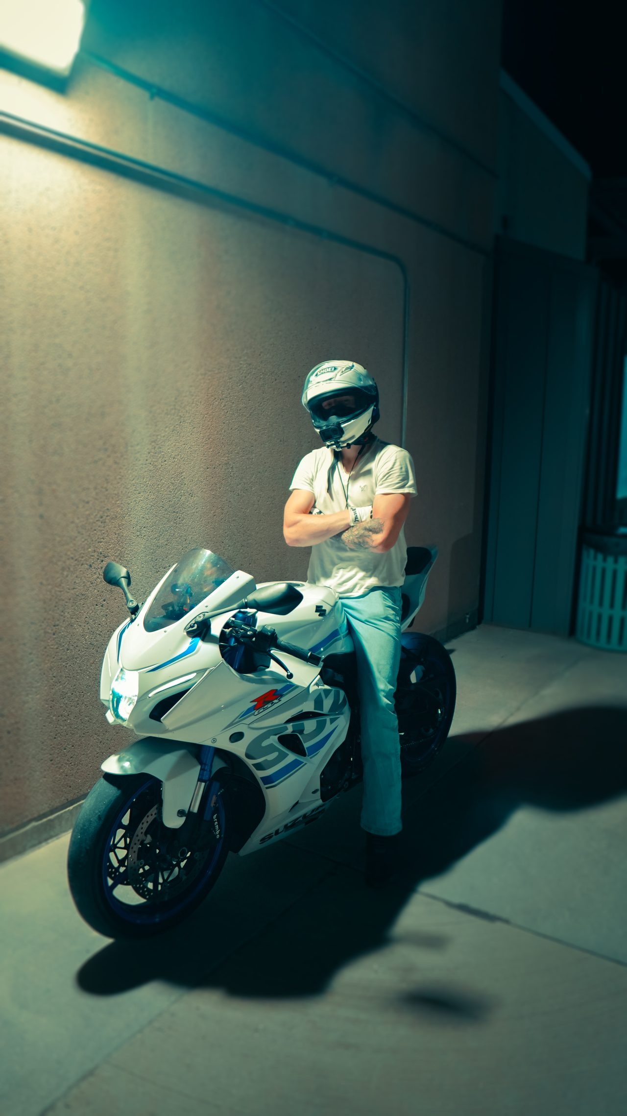 Sport bike and rider in a parking deck at night