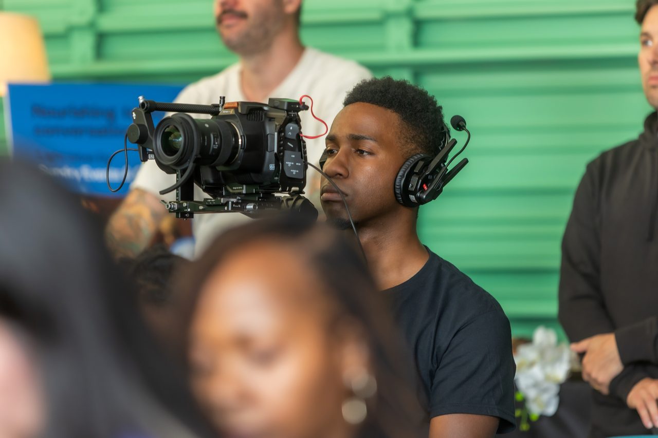Camera operator filming an event from the audience
