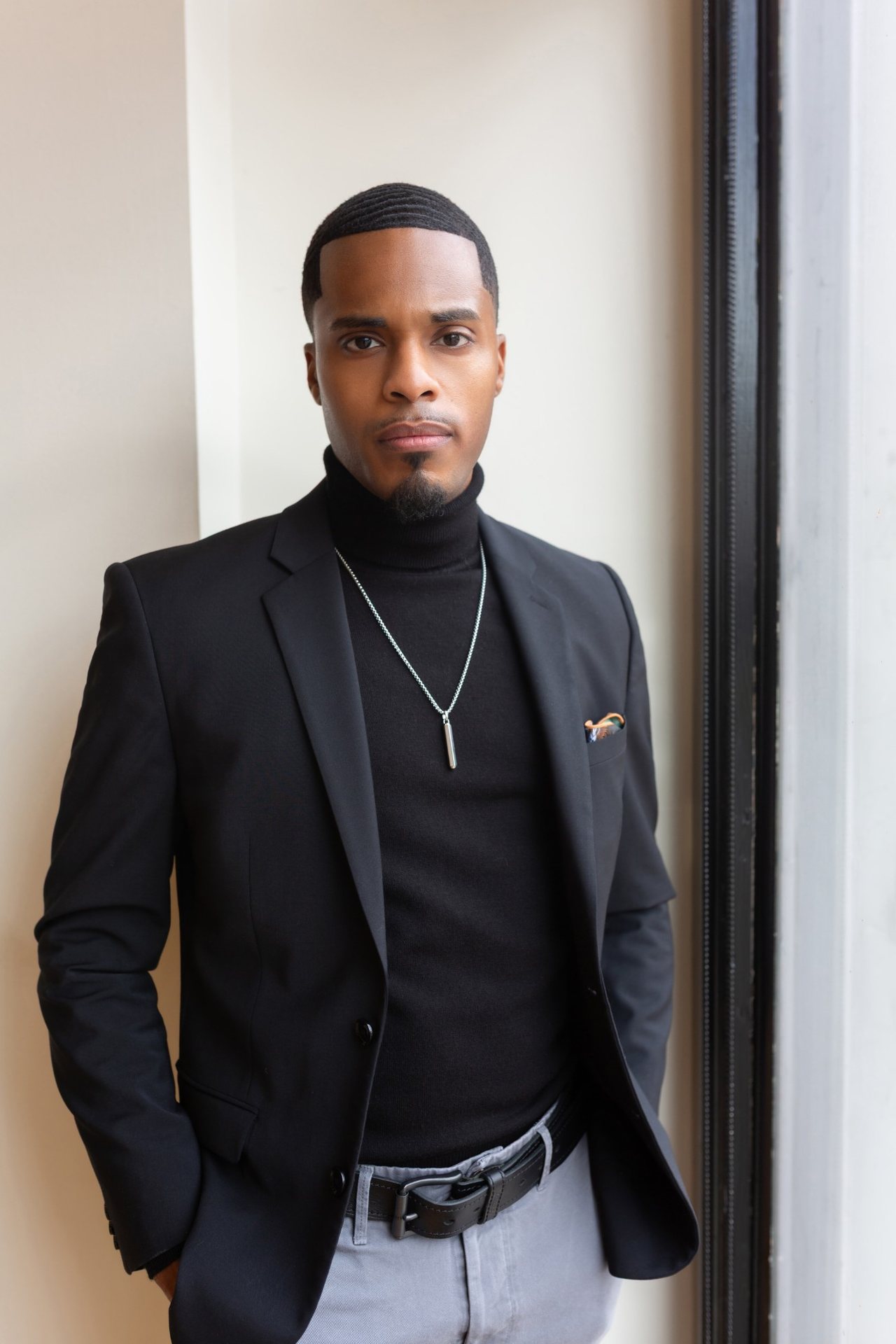 Mosi Nurdeen, founder of Videographer Atlanta, in a black blazer beside a window