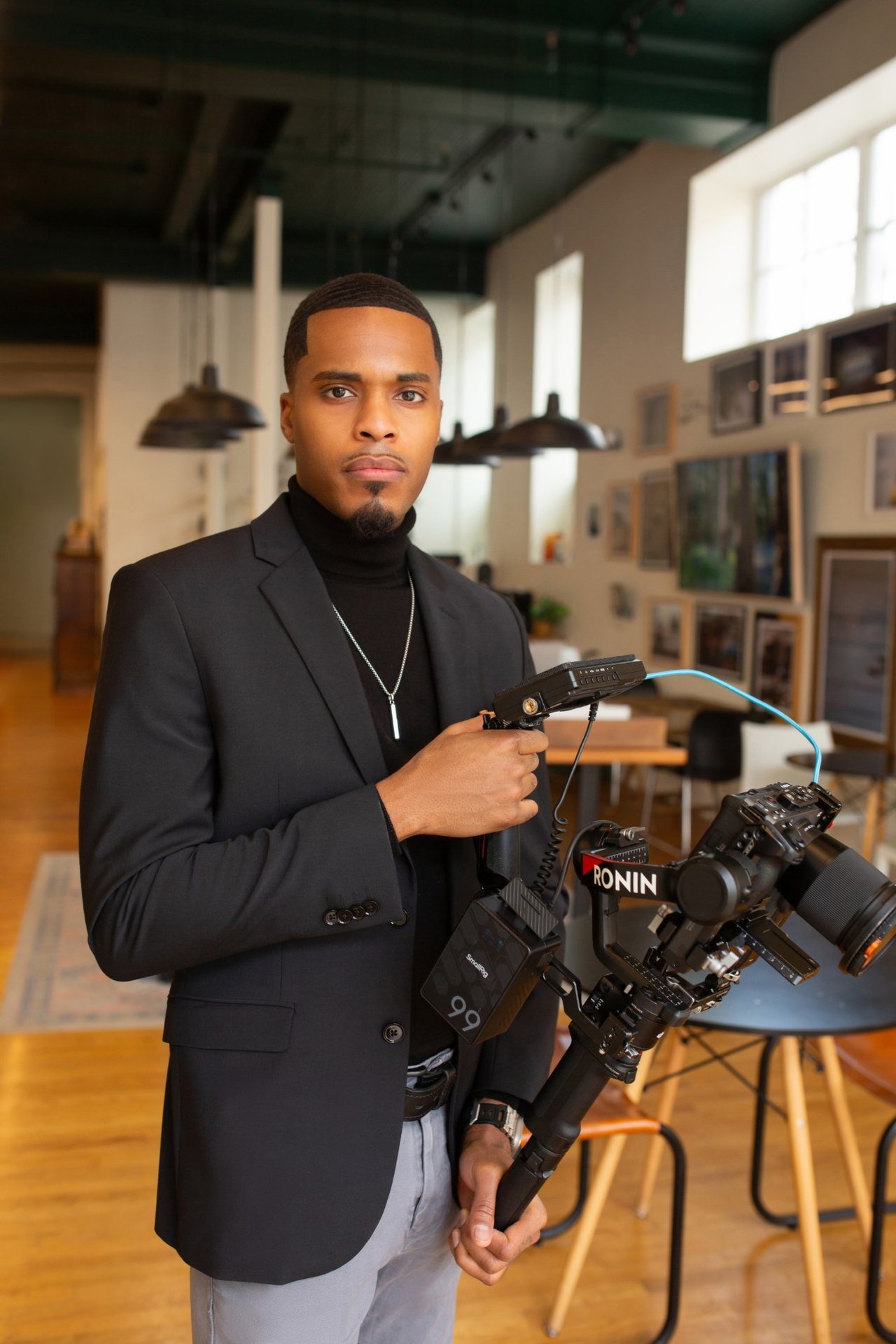 Mosi Nurdeen holding a Ronin gimbal rig in a loft studio